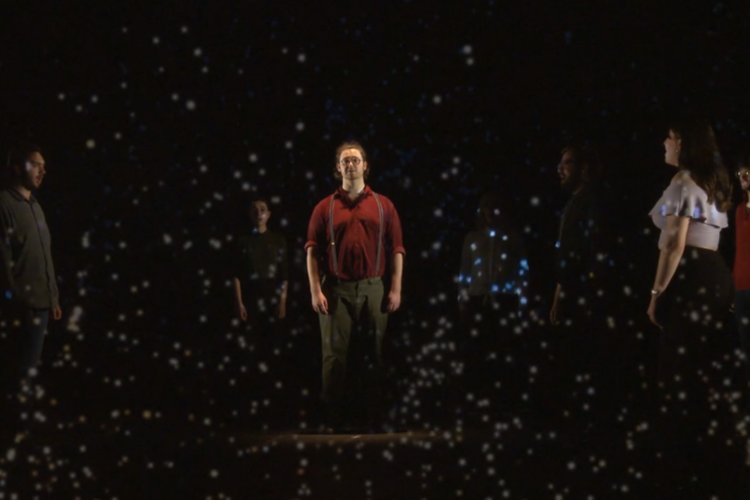 Students perform on stage in front of video projections